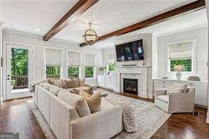 3617 Carson Ln SE, Smyrna, GA 30080 - living room featuring beam ceiling, a fireplace, dark wood finished floors, and a chandelier