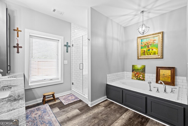 2109 Brewers Mill Rd, Elberton, GA 30635 - full bathroom with a shower stall, wood finished floors, a garden tub, a chandelier, and baseboards