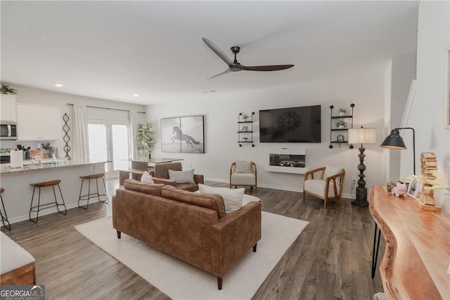 living room featuring a ceiling fan, dark wood finished floors, recessed lighting, and baseboards