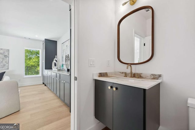 1287 Star Dr NE, Brookhaven, GA 30319 - bathroom featuring wood finished floors, vanity, baseboards, and toilet