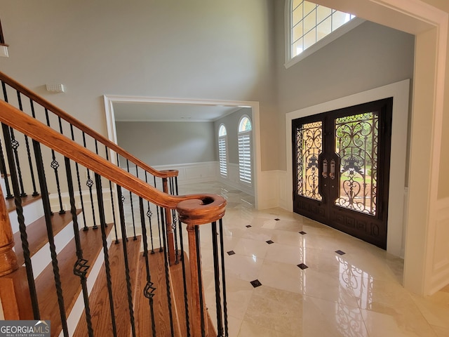 45 Mountain Crest Dr, Oxford, GA 30054 - foyer featuring french doors, a wainscoted wall, stairway, a high ceiling, and tile patterned floors