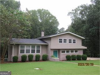 626 Evergreen, Sandersville, GA 31082 - tri-level home with a front yard and a chimney