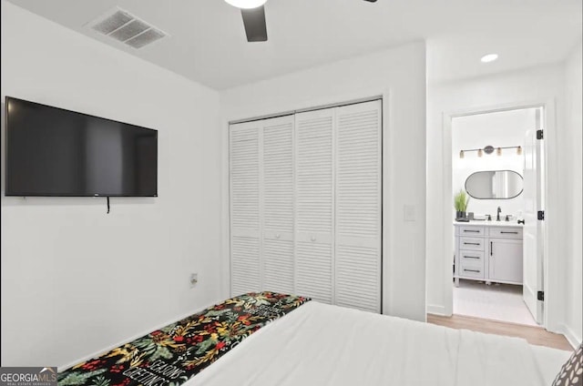 251 Aurora Ave NW, Atlanta, GA 30314 - bedroom featuring a closet, a sink, light wood-style flooring, connected bathroom, and ceiling fan