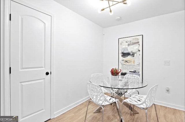 251 Aurora Ave NW, Atlanta, GA 30314 - dining room featuring baseboards, light wood finished floors, and a chandelier
