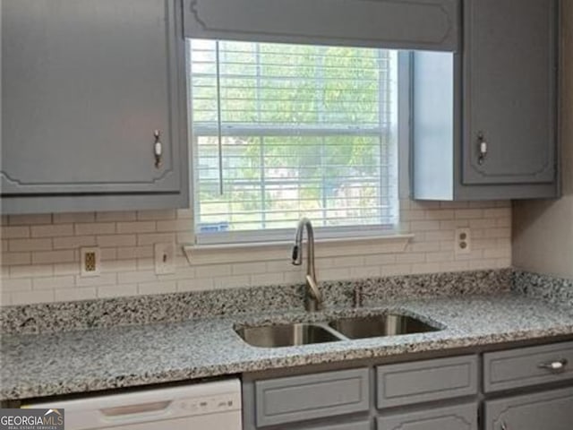 5517 Rock Shoals Way, Atlanta, GA 30349 - kitchen featuring a sink, white dishwasher, decorative backsplash, and gray cabinetry