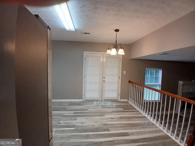 5517 Rock Shoals Way, Atlanta, GA 30349 - entrance foyer with wood finished floors, baseboards, and a chandelier