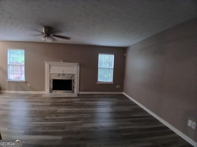 5517 Rock Shoals Way, Atlanta, GA 30349 - unfurnished living room with dark wood-style floors, baseboards, a premium fireplace, and a ceiling fan