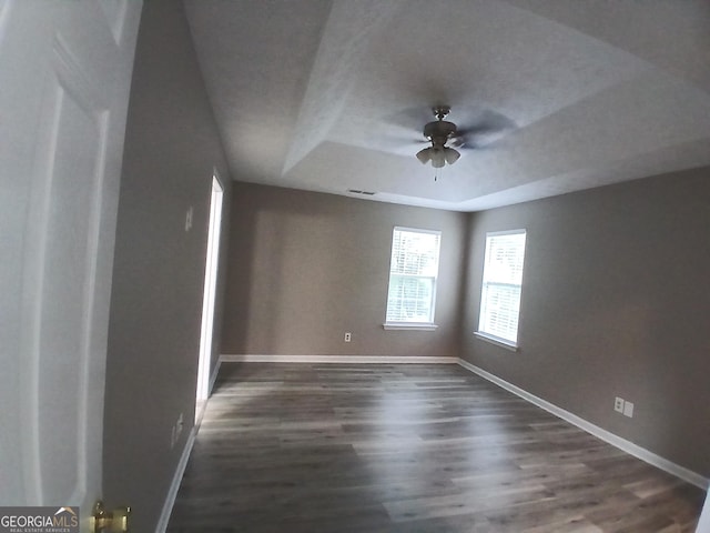 5517 Rock Shoals Way, Atlanta, GA 30349 - unfurnished room with a raised ceiling, a ceiling fan, baseboards, and dark wood-style floors