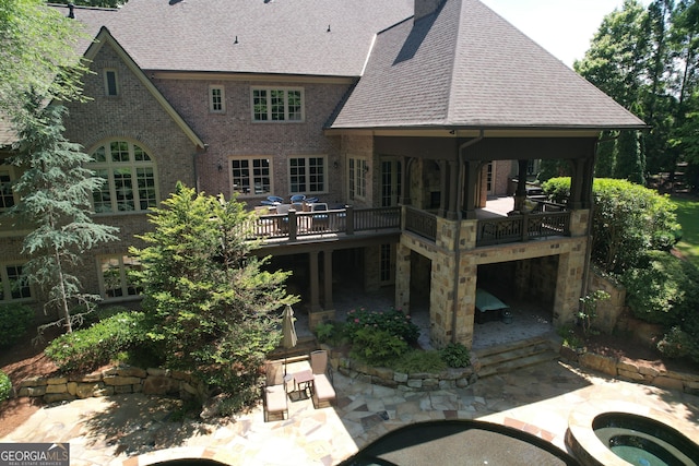 1023 Little Darby Ln, Suwanee, GA 30024 - back of property with a patio area, a shingled roof, a deck, and brick siding