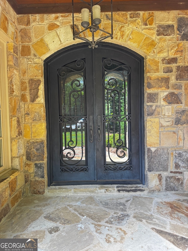 1023 Little Darby Ln, Suwanee, GA 30024 - view of exterior entry featuring stone siding and french doors
