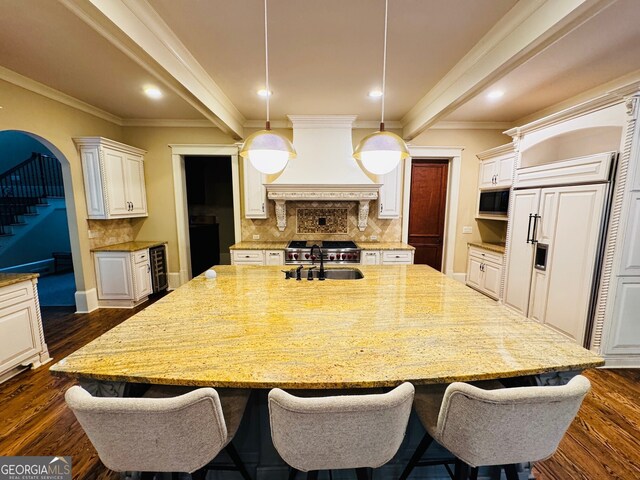 1023 Little Darby Ln, Suwanee, GA 30024 - kitchen featuring custom exhaust hood, a sink, built in appliances, light stone countertops, and dark wood-style flooring