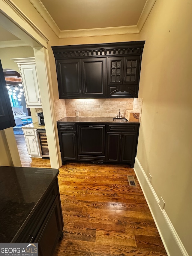 1023 Little Darby Ln, Suwanee, GA 30024 - indoor bar featuring decorative backsplash, crown molding, and dark wood-style floors