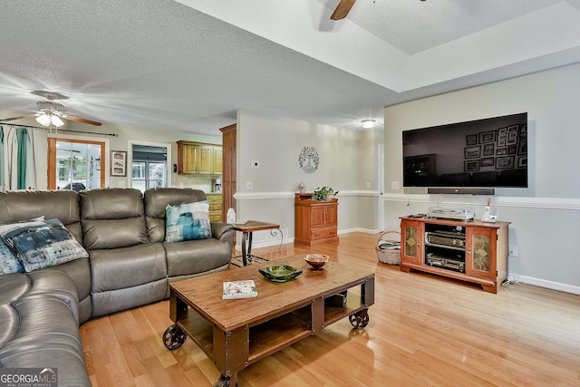 55 Hubbard Ct, Newnan, GA 30263 - living room with a ceiling fan, light wood-style flooring, a textured ceiling, and baseboards