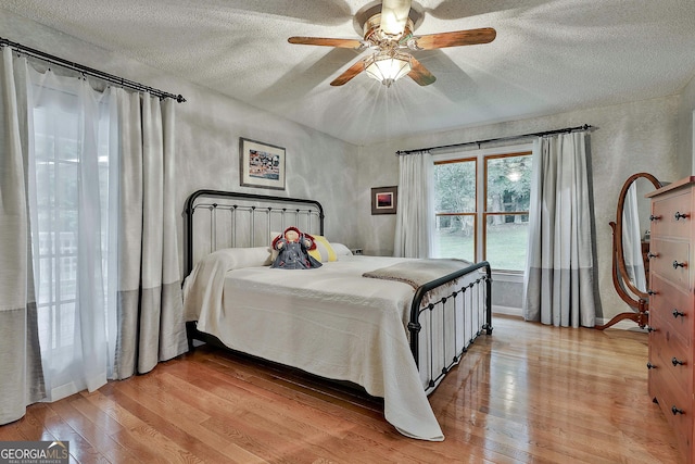 55 Hubbard Ct, Newnan, GA 30263 - bedroom featuring a textured ceiling, light wood-style floors, a ceiling fan, and baseboards