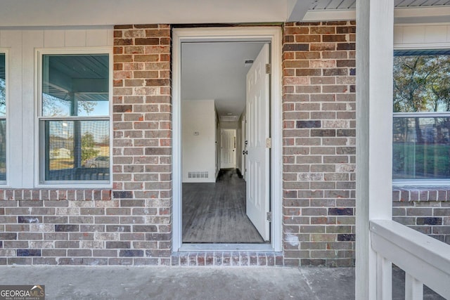 doorway to property with brick siding