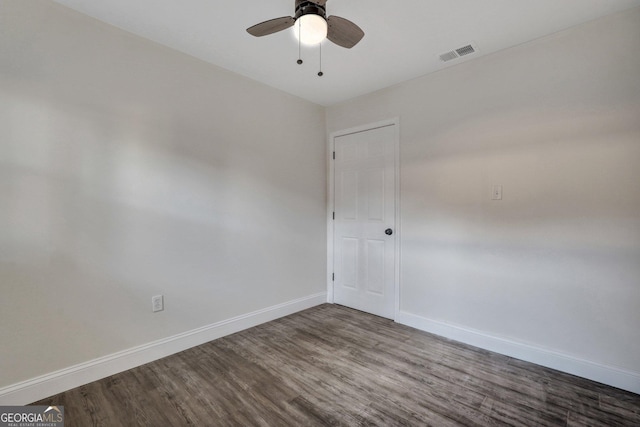 empty room with baseboards, dark wood-style floors, and ceiling fan
