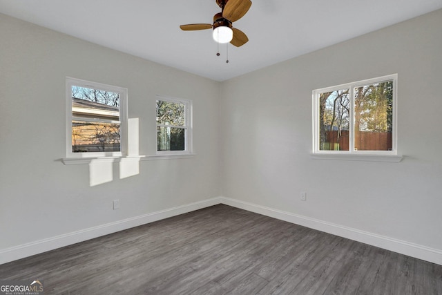 spare room featuring dark wood-style flooring, baseboards, and a ceiling fan