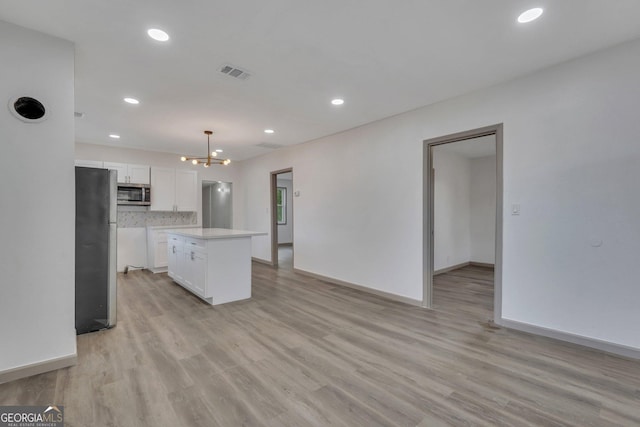 1601 Coventry St, Savannah, GA 31415 - kitchen featuring stainless steel appliances, a chandelier, white cabinets, light wood-style floors, and recessed lighting