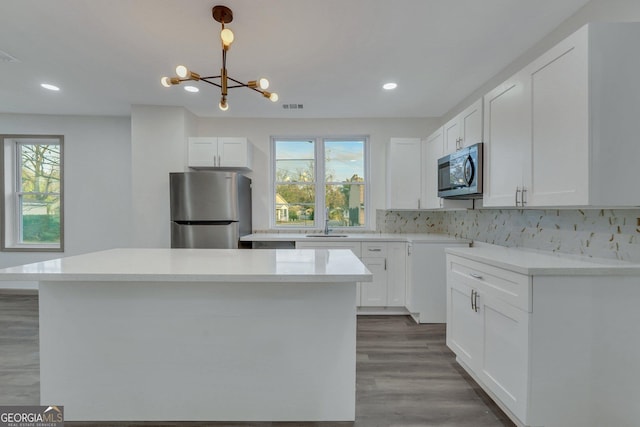 1601 Coventry St, Savannah, GA 31415 - kitchen with appliances with stainless steel finishes, a chandelier, recessed lighting, backsplash, and wood finished floors