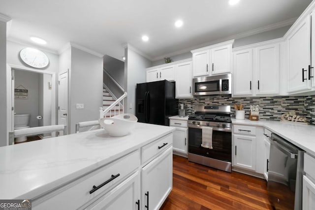 1630 Marsanne Ter NW Unit 27, Kennesaw, GA 30152 - kitchen featuring appliances with stainless steel finishes, tasteful backsplash, dark wood-style flooring, crown molding, and white cabinetry