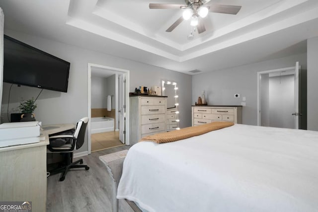 1630 Marsanne Ter NW Unit 27, Kennesaw, GA 30152 - bedroom with light wood-type flooring, a tray ceiling, a desk, ensuite bathroom, and ceiling fan