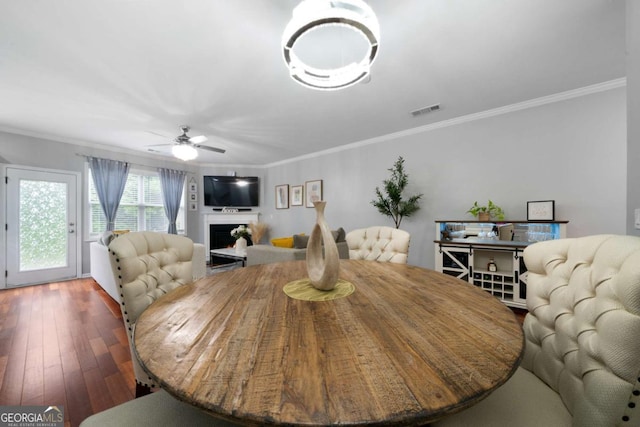 1630 Marsanne Ter NW Unit 27, Kennesaw, GA 30152 - dining area featuring ornamental molding, a ceiling fan, hardwood / wood-style floors, and a warm lit fireplace