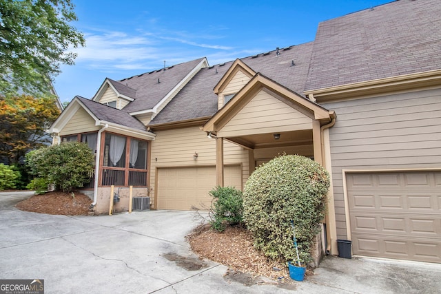 2551 Village Creek Lndg SE, Atlanta, GA 30316 - view of front of house featuring a sunroom, driveway, a garage, a shingled roof, and central AC