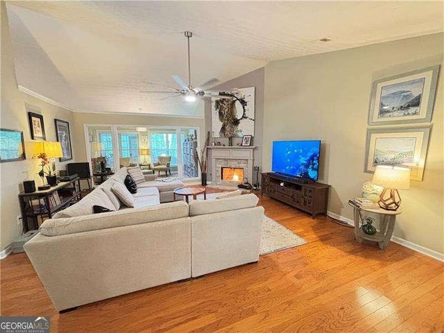 4025 Mcdowell Dr, Acworth, GA 30101 - living area featuring a ceiling fan, baseboards, a lit fireplace, light wood-style floors, and lofted ceiling