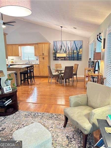 4025 Mcdowell Dr, Acworth, GA 30101 - living area with lofted ceiling, plenty of natural light, light wood-style floors, and a ceiling fan