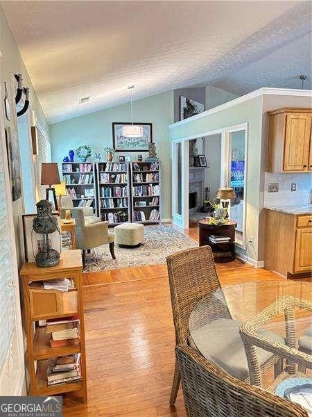 4025 Mcdowell Dr, Acworth, GA 30101 - dining room featuring vaulted ceiling, light wood-style flooring, and baseboards
