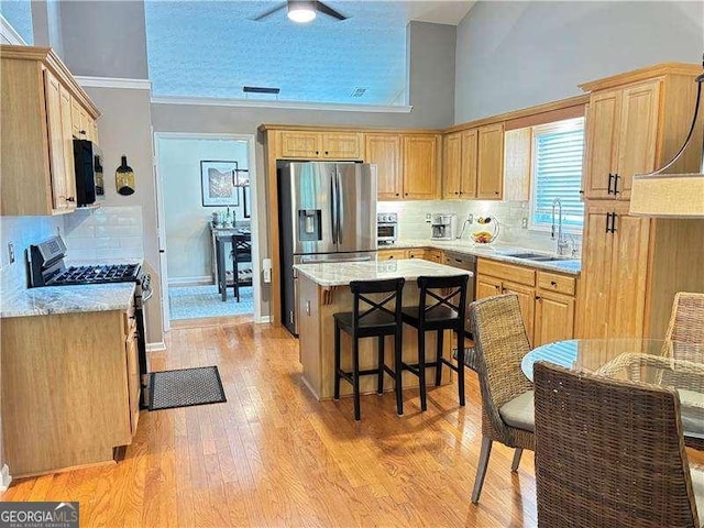 4025 Mcdowell Dr, Acworth, GA 30101 - kitchen with a sink, appliances with stainless steel finishes, a kitchen island, backsplash, and a breakfast bar area