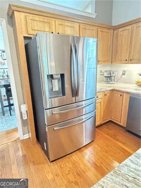 4025 Mcdowell Dr, Acworth, GA 30101 - kitchen with appliances with stainless steel finishes, light wood-type flooring, light brown cabinetry, and light stone countertops