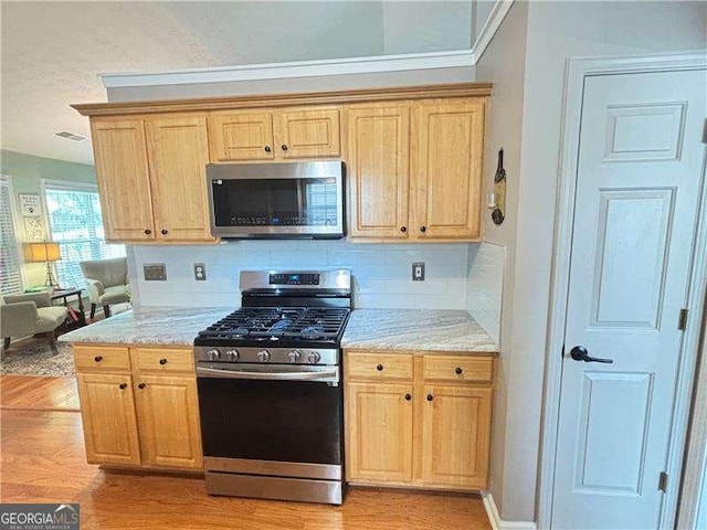 4025 Mcdowell Dr, Acworth, GA 30101 - kitchen with appliances with stainless steel finishes, light wood-style floors, tasteful backsplash, and light stone countertops
