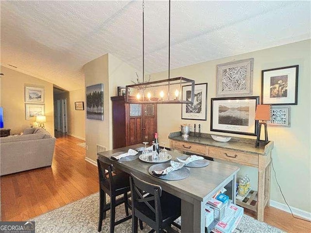 4025 Mcdowell Dr, Acworth, GA 30101 - dining area featuring a textured ceiling, wood finished floors, and baseboards