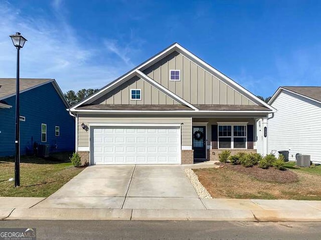 craftsman-style house featuring board and batten siding, brick siding, concrete driveway, a garage, and central AC unit