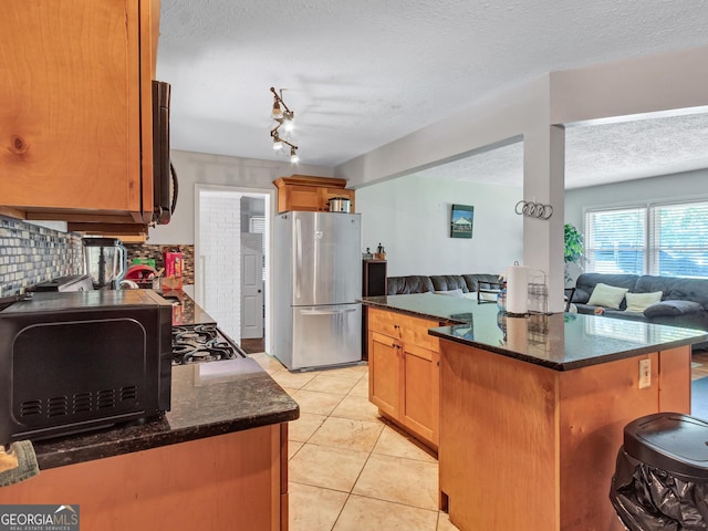 3059 Will Rogers Pl SE, Atlanta, GA 30316 - kitchen with freestanding refrigerator, open floor plan, a textured ceiling, dark stone countertops, and a kitchen island