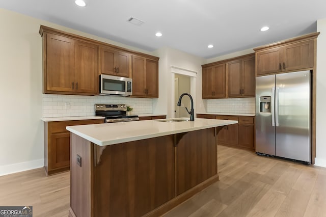 113 Summit View Ln, Ellijay, GA 30540 - kitchen featuring stainless steel appliances, a sink, light wood finished floors, backsplash, and a breakfast bar area