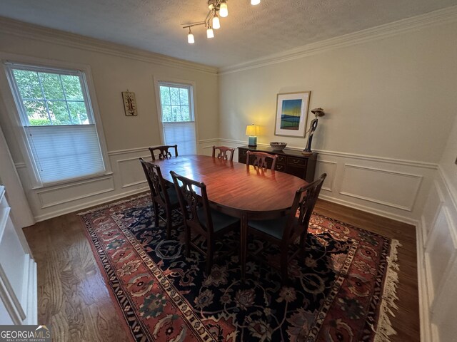 3146 Weymouth Dr, Marietta, GA 30062 - dining room featuring dark wood-style floors, a textured ceiling, a decorative wall, ornamental molding, and a wainscoted wall