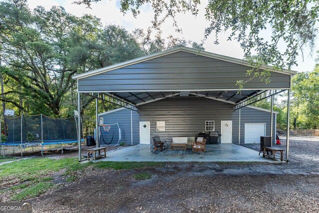 1208 Nease Rd, Guyton, GA 31312 - view of car parking featuring a trampoline and a garage