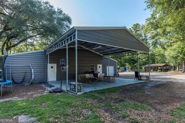 1208 Nease Rd, Guyton, GA 31312 - back of house featuring a trampoline and a carport