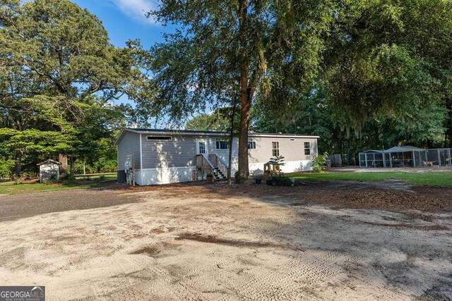 1208 Nease Rd, Guyton, GA 31312 - view of front of property with a storage unit, an outdoor structure, and view of wooded area