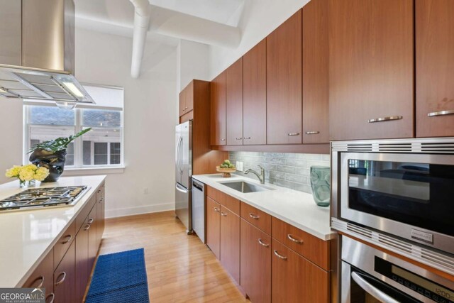 1058 Piedmont Ave Unit 103, Atlanta, GA 30309 - kitchen with a sink, island exhaust hood, stainless steel appliances, light countertops, and light wood-style floors