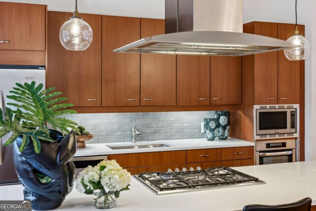 1058 Piedmont Ave Unit 103, Atlanta, GA 30309 - kitchen featuring island exhaust hood, stainless steel appliances, a sink, light countertops, and brown cabinetry