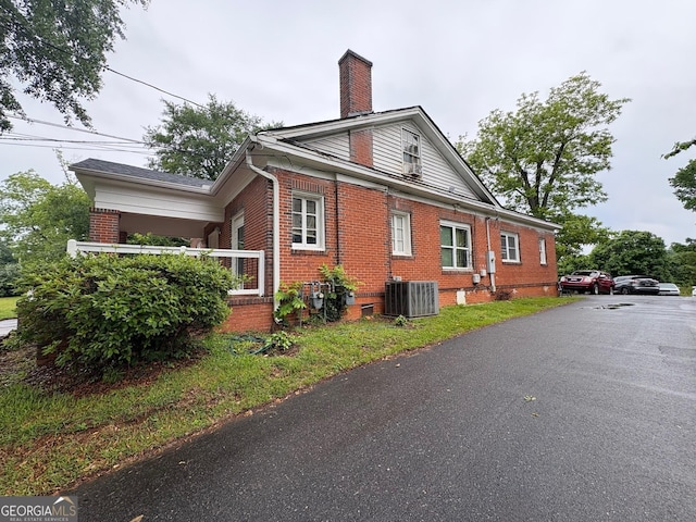 720 W Main St, Thomaston, GA 30286 - view of side of home with brick siding, central AC, and a chimney