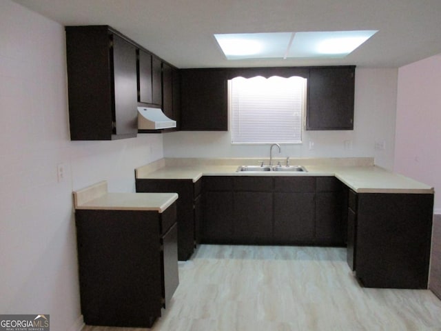 102 Westcliff Ctr Unit D, Warner Robins, GA 31093 - kitchen with range hood, a sink, dark cabinetry, and light countertops