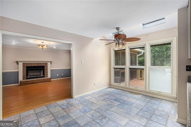 106 Waterford Pl, Acworth, GA 30101 - unfurnished living room with baseboards, light stone finish floors, ceiling fan, a brick fireplace, and ornamental molding