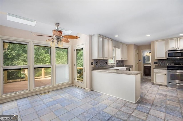 106 Waterford Pl, Acworth, GA 30101 - kitchen with appliances with stainless steel finishes, a sink, tasteful backsplash, a skylight, and a ceiling fan