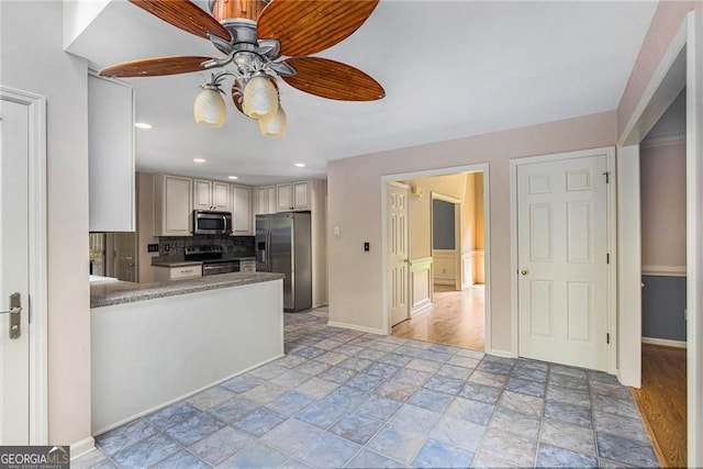 106 Waterford Pl, Acworth, GA 30101 - kitchen featuring appliances with stainless steel finishes, light stone finish flooring, ceiling fan, cream cabinetry, and baseboards
