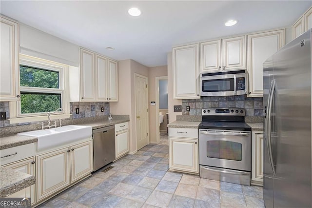 106 Waterford Pl, Acworth, GA 30101 - kitchen featuring stainless steel appliances, cream cabinetry, a sink, backsplash, and recessed lighting