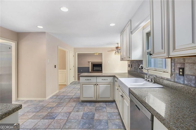 106 Waterford Pl, Acworth, GA 30101 - kitchen featuring stainless steel dishwasher, a sink, a fireplace, ceiling fan, and decorative backsplash